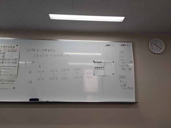 試験室前方の座席番号や試験時間などの書かれたホワイトボード